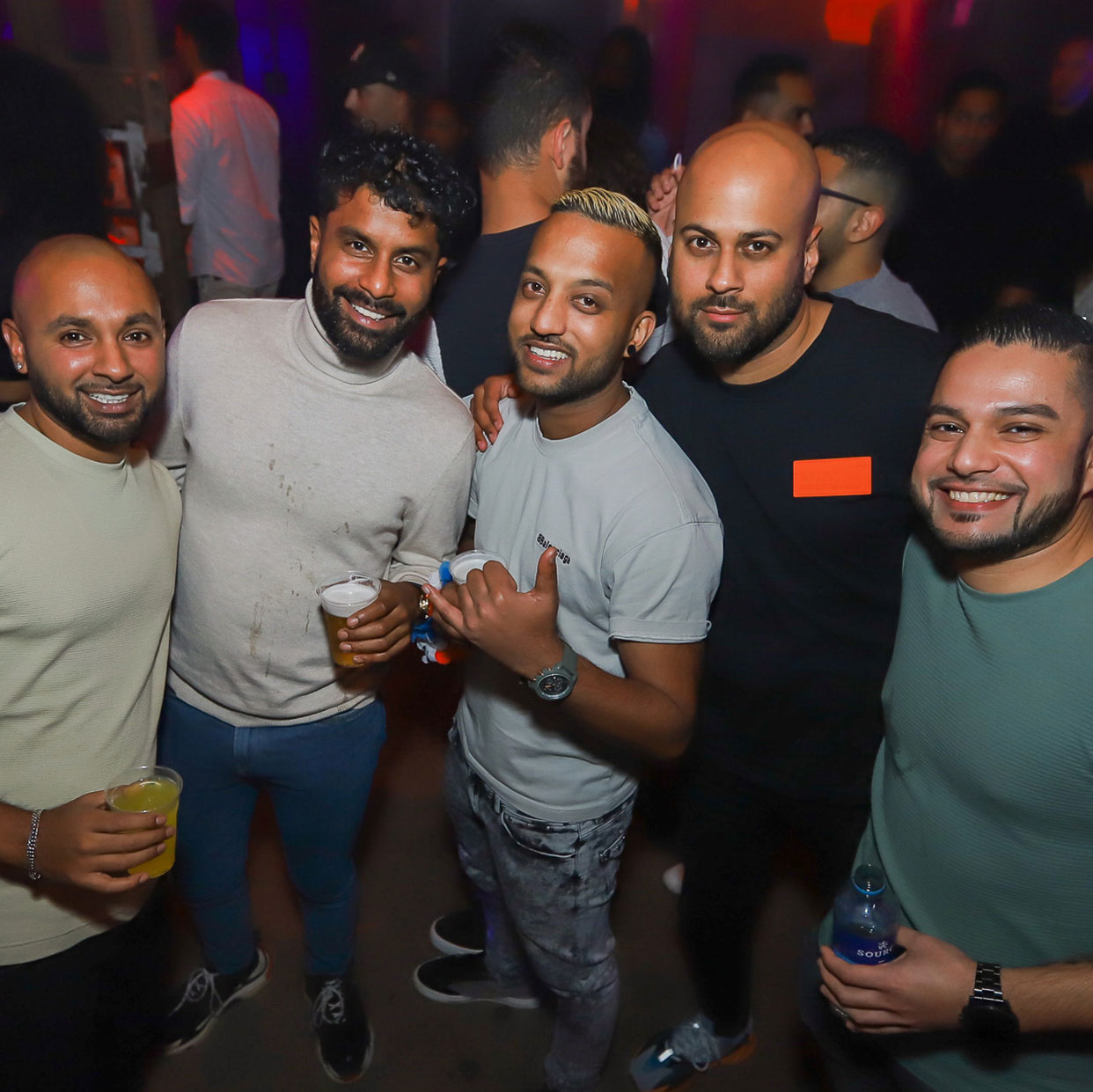 Vrienden poseren met drankjes op de dansvloer van Tesa Fesa 2023